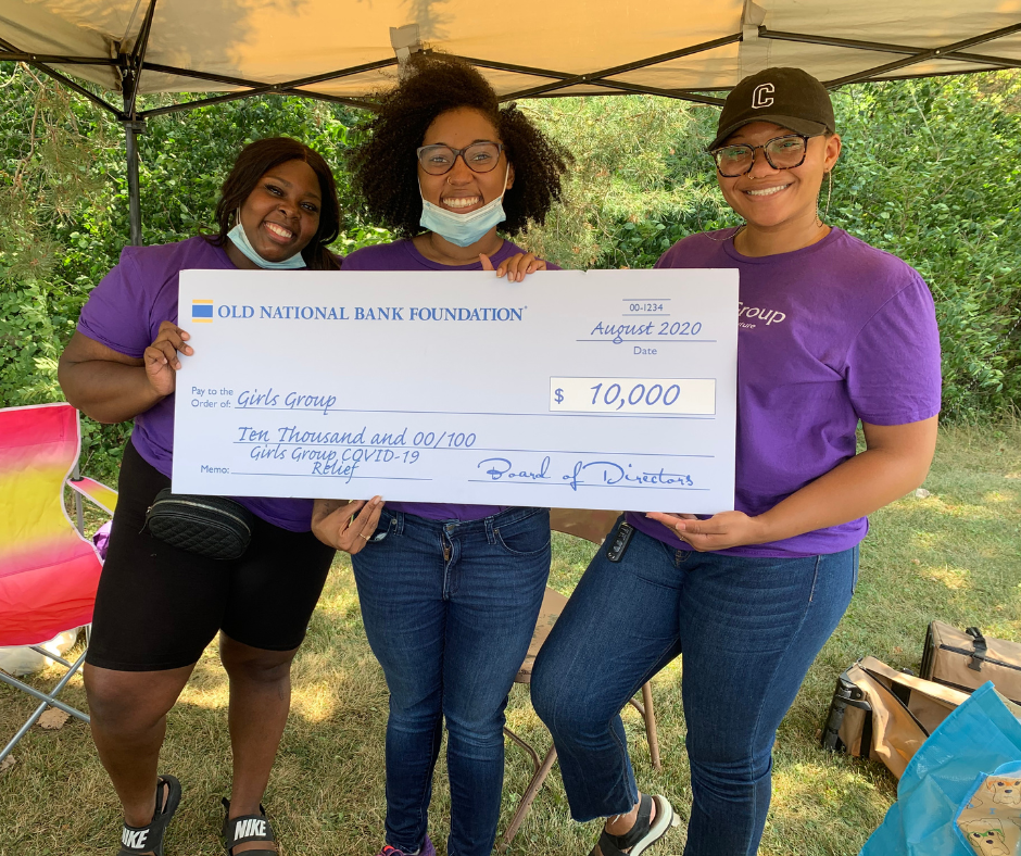 Staff holding COVID-19 relief check from community funder