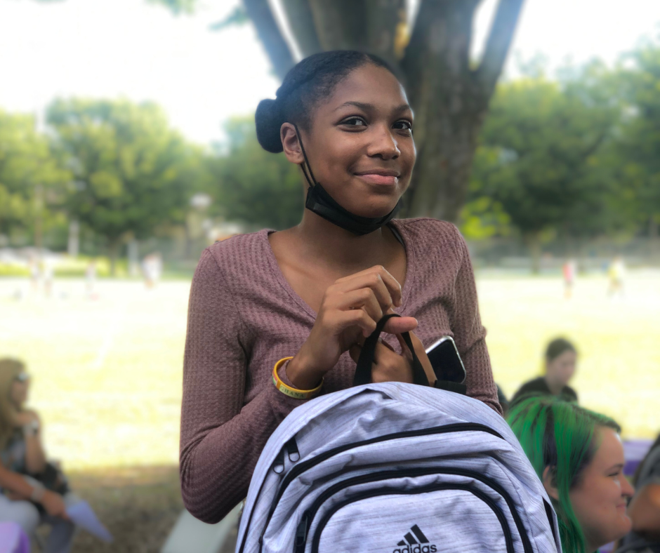 Participant receiving free backpack at back to school event